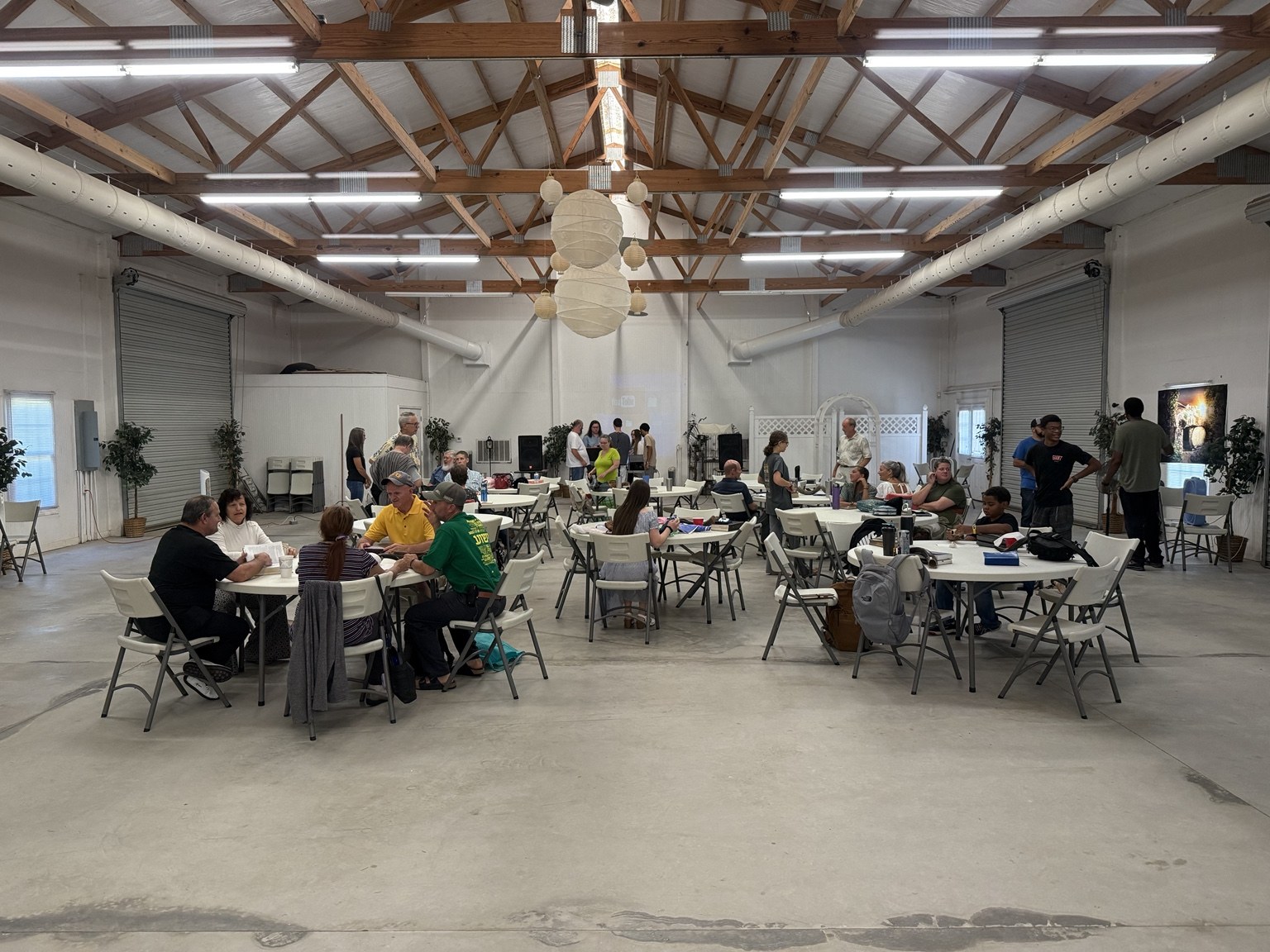 A large gathering around tables in the hall